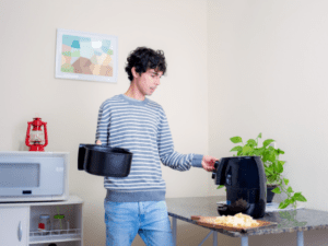 A man preparing to cook a fries using air fryer (1)