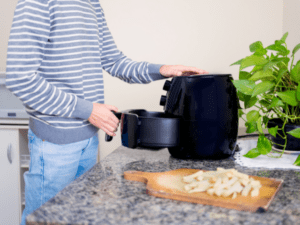 A man preparing to cook a fries using air fryer