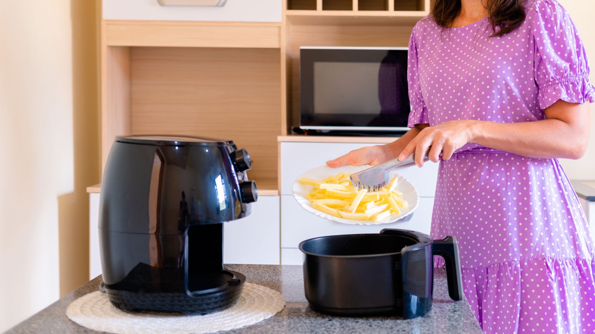 woman using an air fryer with timer