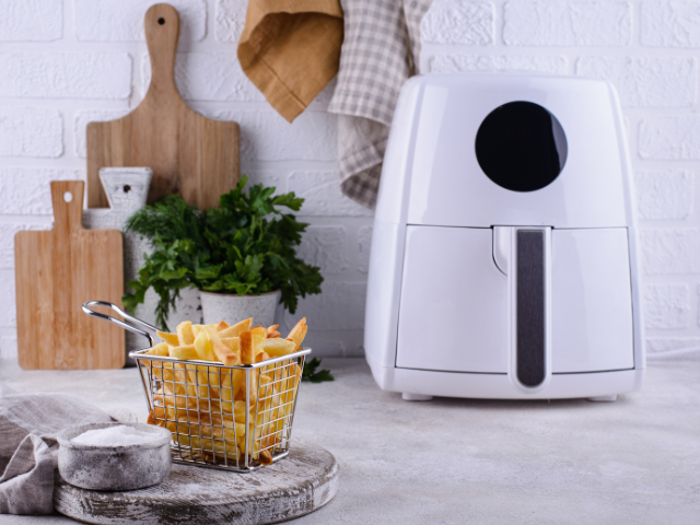 A white air fryer beside a cripsy fries