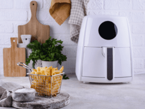 A white air fryer beside a cripsy fries