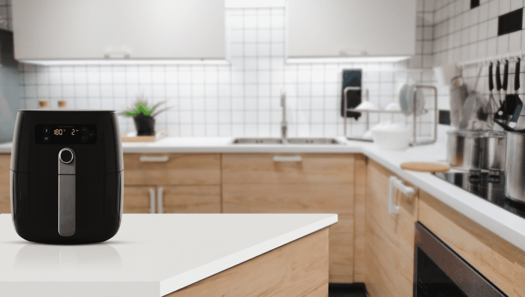 An air fryer displayed on a white countertop in a modern kitchen.