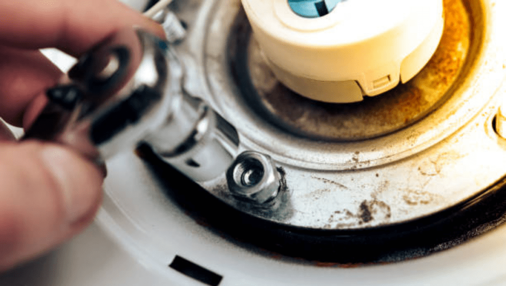 A hand using a wrench to tighten a bolt on a mechanical part.