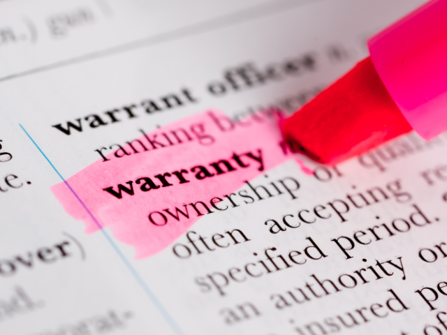 A close-up of the word "warranty" being highlighted in pink in a dictionary entry.