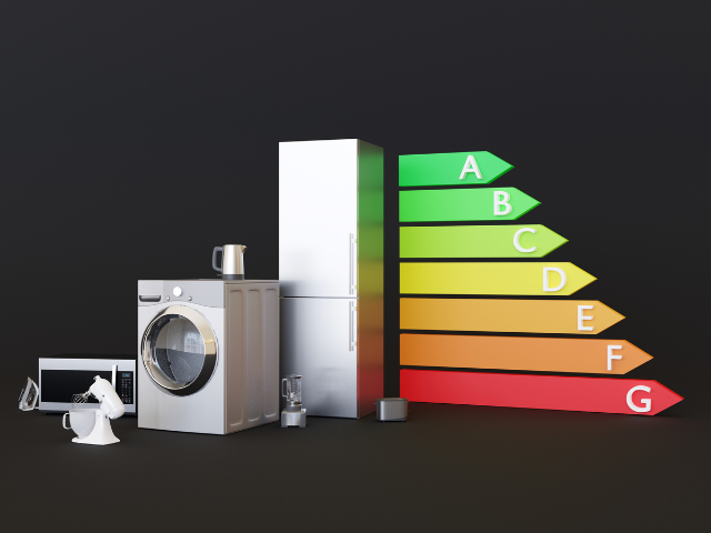 A collection of household appliances next to a colorful energy efficiency rating scale from A to G.