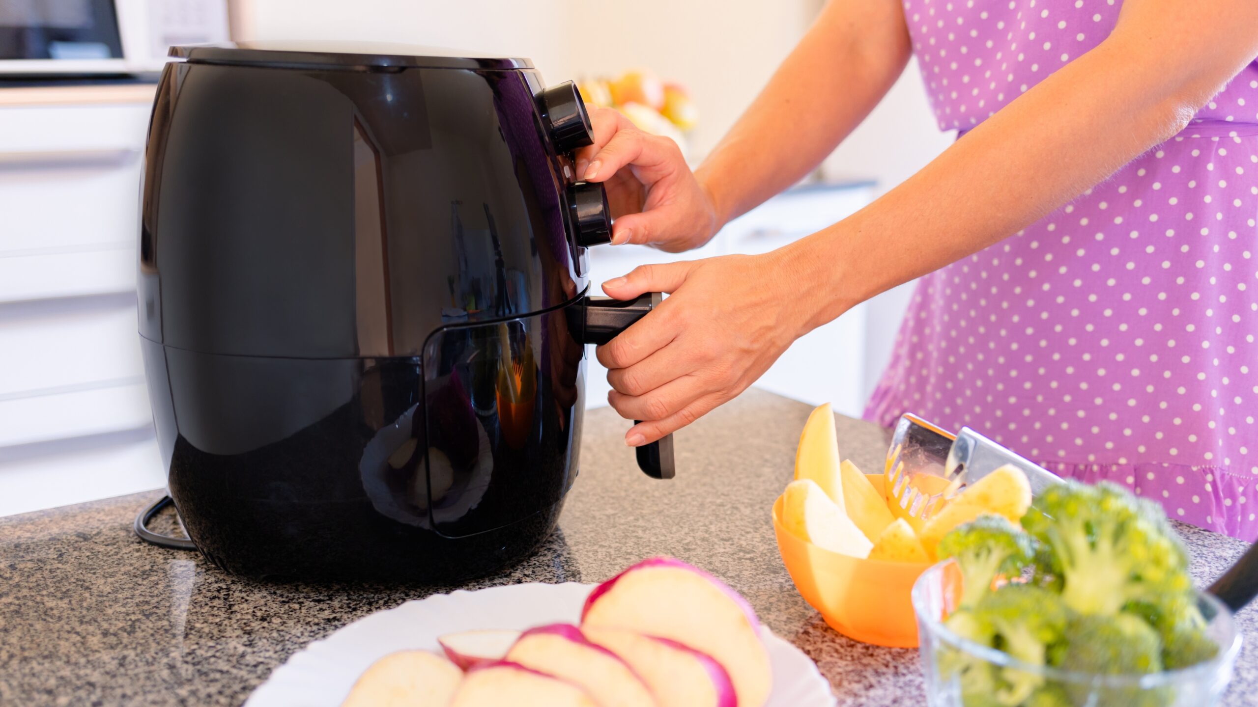 woman using air fryer to cook